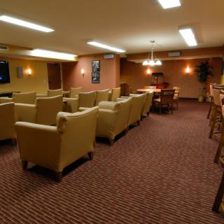 A cozy lounge area with comfortable seating and a large TV.