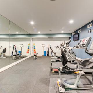 A modern gym with exercise equipment and mirrored walls.
