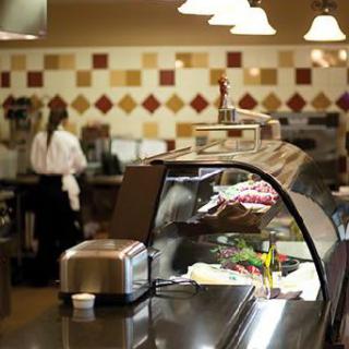 A deli counter in a restaurant with various meats and cheeses on display.