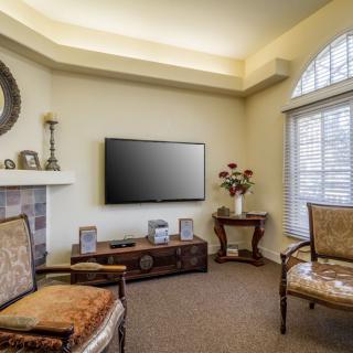 A cozy living room with elegant furniture and a mounted TV.