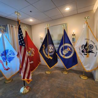 A display of military and national flags representing various branches of the U.S. Armed Forces.