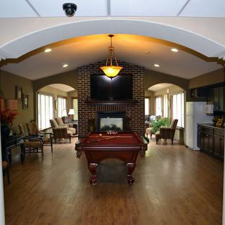 A stylish lounge area featuring a pool table, comfortable seating, and a television.