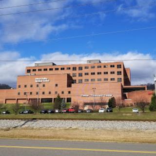 A view of a modern hospital building against a partly cloudy sky.