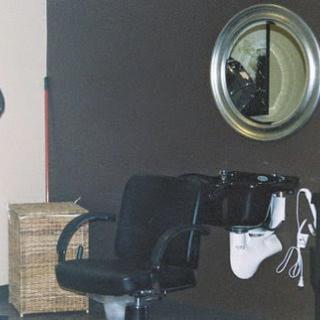 A stylish barber chair in a modern salon setting, complete with a mirror and hair tools.