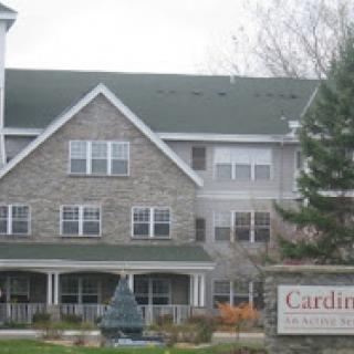 Exterior view of a residential building with a stone facade and signage.