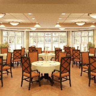 A well-lit dining area with multiple tables and chairs arranged neatly.