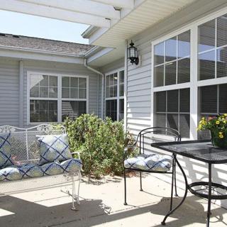 A sunny patio with outdoor furniture and potted plants.
