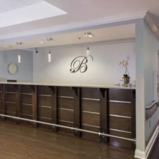 A modern reception area featuring a wooden desk and elegant decor.