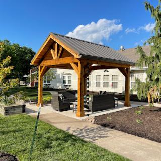 A cozy outdoor pavilion with comfortable seating, perfect for enjoying sunny days in the garden.