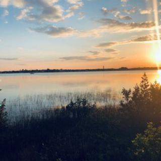 A tranquil sunset over the lake, reflecting the vibrant colors of the sky.