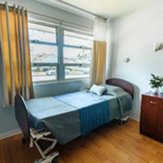 A minimalist room with a single hospital bed and large window.