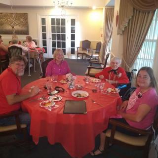 A group of people enjoying a meal together at a dining table indoors.