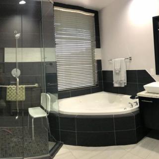 A modern bathroom with a corner bathtub and a glass-enclosed shower.
