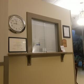 A cozy reception area featuring a clock and various certificates on the wall.
