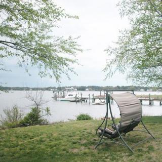 A peaceful lakeside view with a relaxing chair and dock.