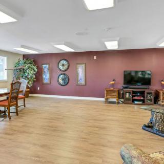 A spacious living room featuring hardwood floors, a wall-mounted television, and stylish decor.