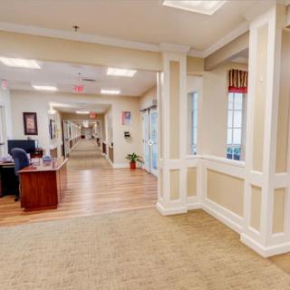 A spacious office hallway with a desk and warm lighting.