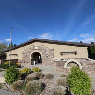 A beautifully designed building with stone accents and lush landscaping under a clear blue sky.