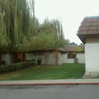 A suburban house surrounded by trees and a neatly maintained yard.