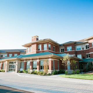 A large brick building with multiple windows under a clear blue sky.