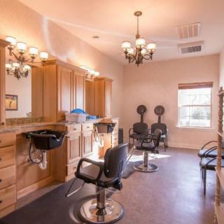 A well-lit hair salon with styling stations and chairs.
