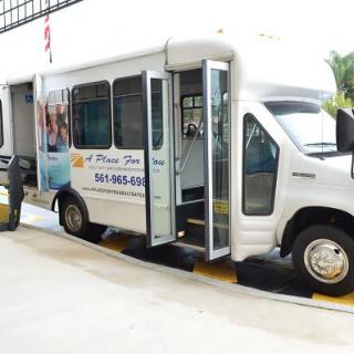 A shuttle van with a wheelchair lift being deployed.
