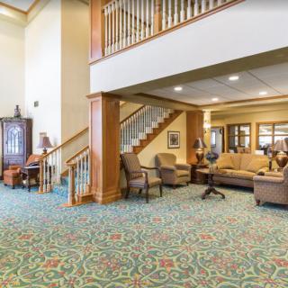 A spacious lobby interior with a seating area and staircase.