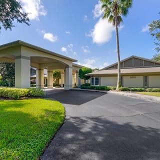 A sunny day at a residential building with a driveway and well-maintained landscaping.