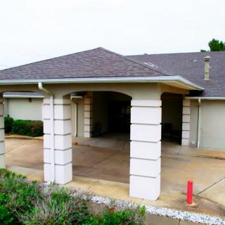 Suburban house with a covered driveway and columned entrance.