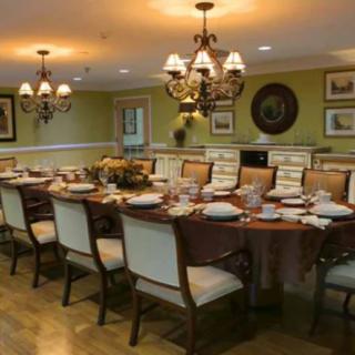 An elegant dining room with a formal table setting and chandeliers.