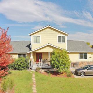 A two-story suburban house with a well-maintained front yard and a car parked in the driveway.