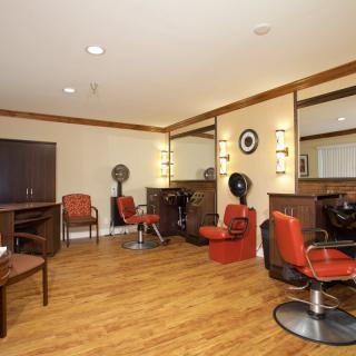 A modern hair salon with chairs, mirrors, and hair dryers, showcasing a clean and inviting interior design.