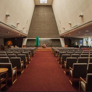 A modern church interior with rows of seating facing the altar.