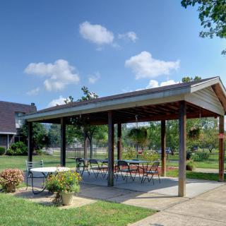 An outdoor pavilion with tables and chairs set under a clear blue sky.