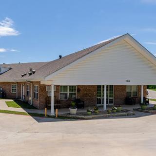 A commercial building with a driveway under a clear blue sky.