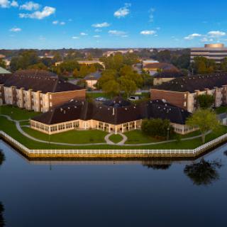 A serene waterfront property showcasing elegant architecture and lush green landscaping.