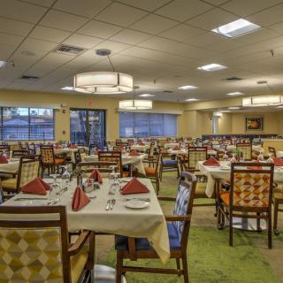 A spacious and elegantly decorated dining room with neatly arranged tables set for guests.