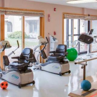 A well-equipped gym with stationary bikes and therapy balls for exercise and rehabilitation.
