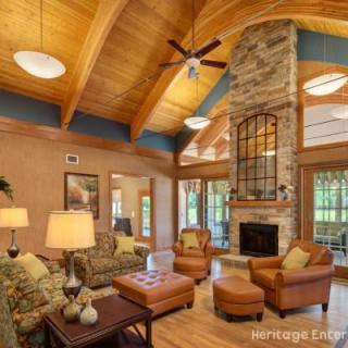 A cozy rustic living room featuring a wood ceiling and stone fireplace.