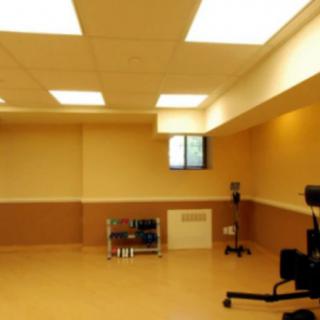 An empty basement room with fluorescent lighting and an office chair.