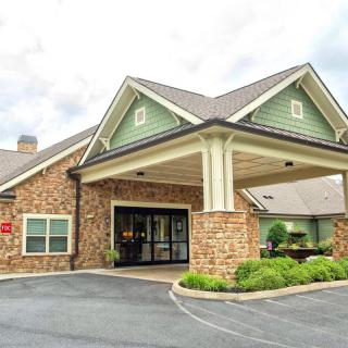 A welcoming entrance to a building with a brick exterior and well-maintained landscaping.