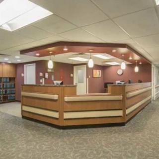 A modern office reception area with a central desk and warm lighting.
