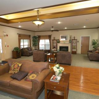 A spacious and comfortably furnished living room with a fireplace and cozy seating arrangements.