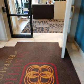 The welcoming entrance of a hotel lobby, featuring a decorative mat and reception area.