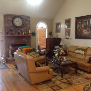 A cozy living room featuring a fireplace, leather sofas, and tasteful decor.