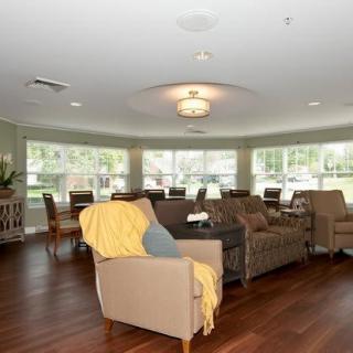 A spacious living room with comfortable seating and large windows providing natural light.