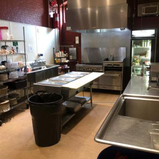 A clean and organized commercial kitchen with stainless steel appliances.