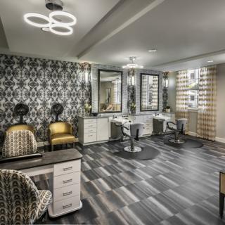 A modern salon with stylish decor, featuring hairdressing stations and seating.