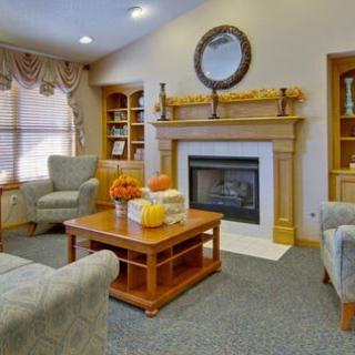 A cozy living room with a fireplace and autumn-themed decorations.