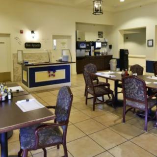An empty restaurant dining area with tables and chairs arranged neatly.